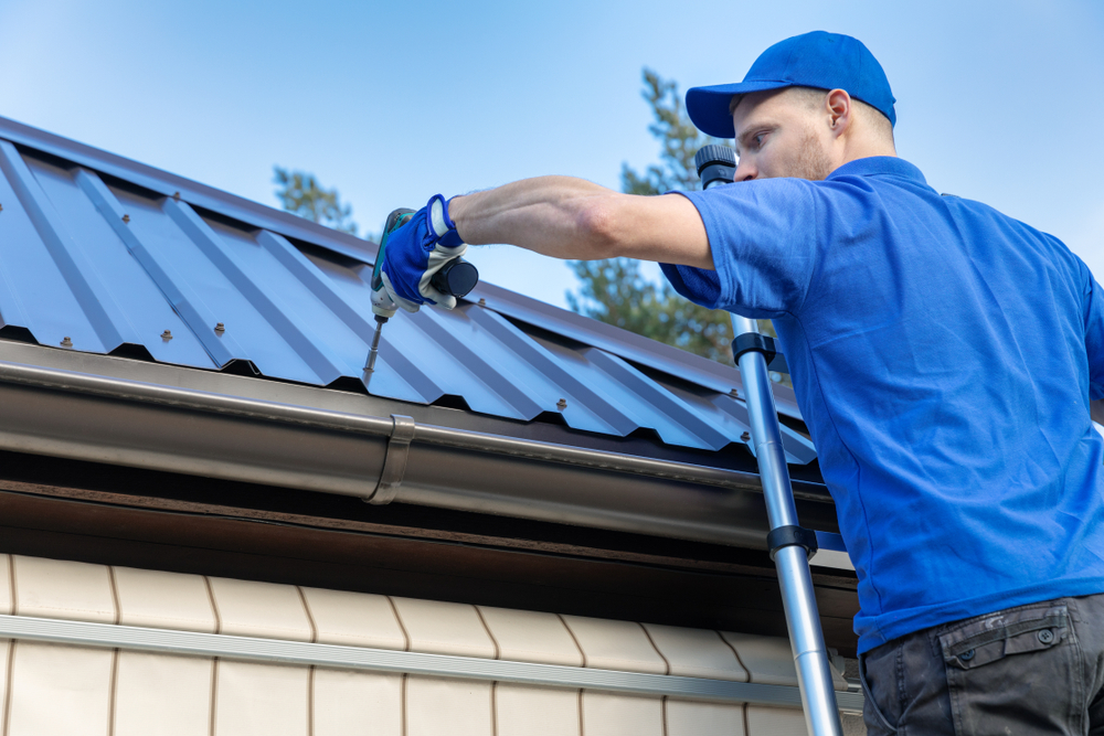 Metal,Roofing,-,Roofer,Working,On,The,House,Roof